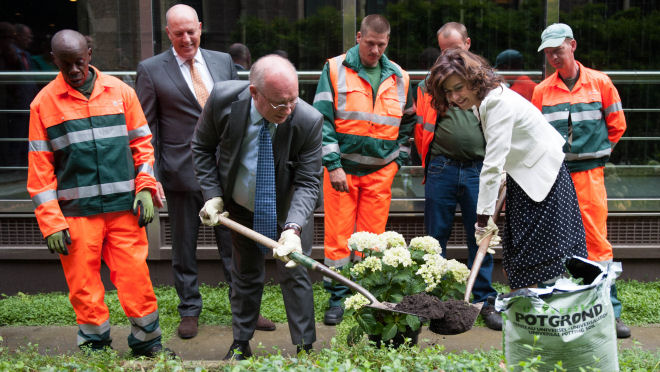 Voorzitter van de Tweede Kamer en wethouder van de gemeente Den Haag planten groen onder toeziend oog van medewerkers van de Haeghe Groep