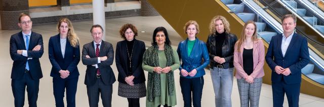 De commissieleden staan op een rij voor de roltrap in de Statenpassage