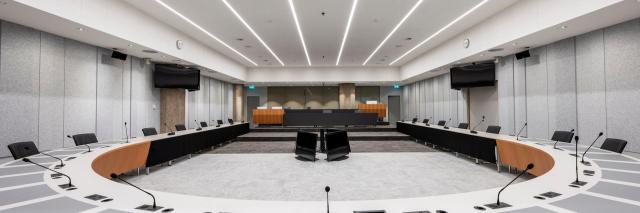 Lege Troelstrazaal, een van de commissiezalen van de Tweede kamer. Op de voorgrond de U-vormige vergaderopstelling, achterin de publieke tribune.