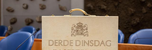 Beeld van lichtgekleurd rechtopstaand koffertje met opdruk 'Derde dinsdag van september'