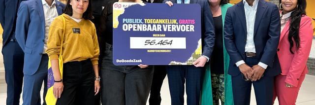 Groepsfoto in de Statenpassage. Op de foto staan de initiatiefnemers van DeGoedeZaak en de leden van de commissie voor de Verzoekschriften en de Burgerinitiatieven. Twee van hen houden een bord ivast, waarop staat: Publiek, toegankelijk, gratis openbaar vervoer. Meer dan 56.464 handtekeningen!