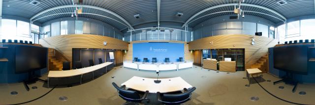 Panorama van de enquêtezaal, met tafels en tribune.