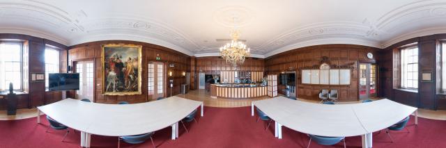 Panorama van de Koffiekamer, met rood tapijt en witte tafels.
