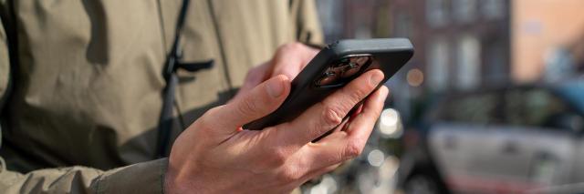 Een persoon kijkt naar zijn of haar mobiele telefoon.