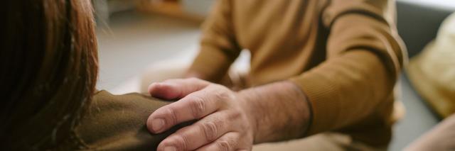 Man legt arm op schouder van vrouw.