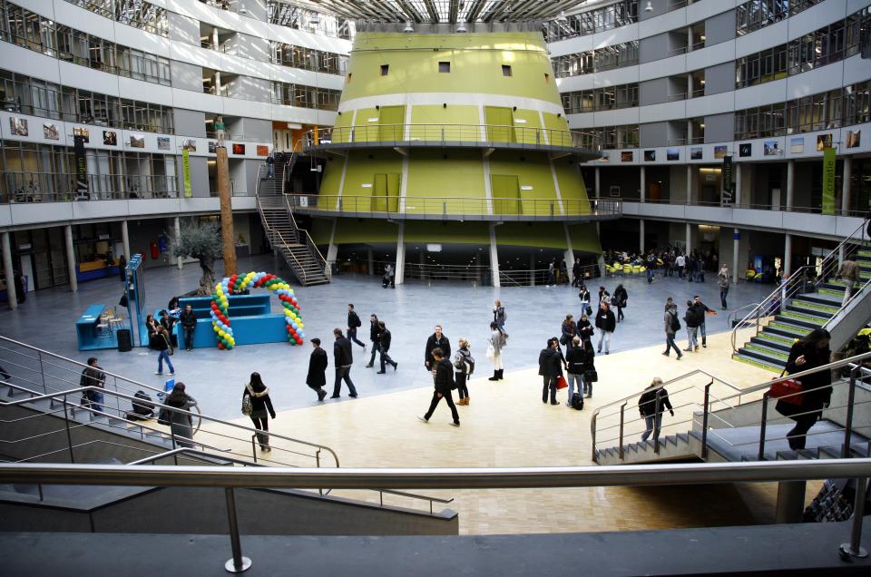 Students walk in opposite directions in a hall at The Hague University of Applied Sciences.