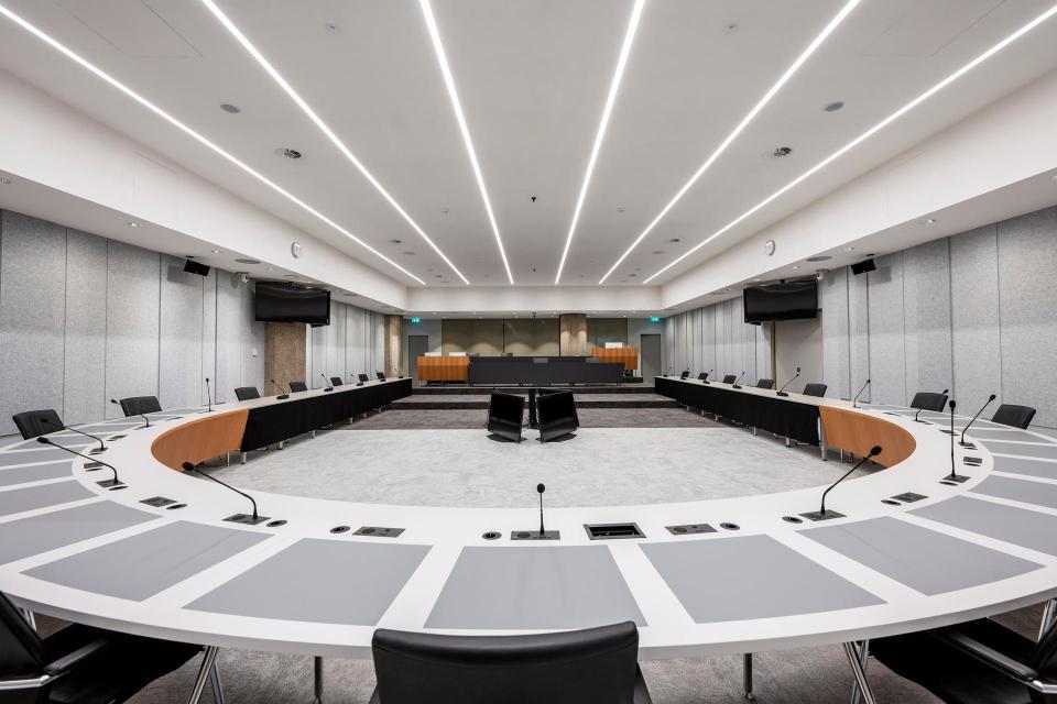 Lege Troelstrazaal, een van de commissiezalen van de Tweede kamer. Op de voorgrond de U-vormige vergaderopstelling, achterin de publieke tribune.