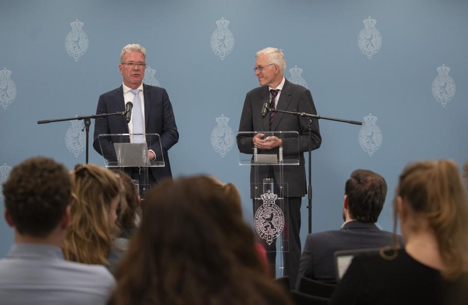 Informateurs Elbert Dijkgraaf en Richard van Zwol staan beiden voor een katheder met een microfoon. Op de achtergrond een blauw scherm met logo’s van de Tweede Kamer. Op de voorgrond achterhoofden van mensen die zitten te kijken naar het persmoment.