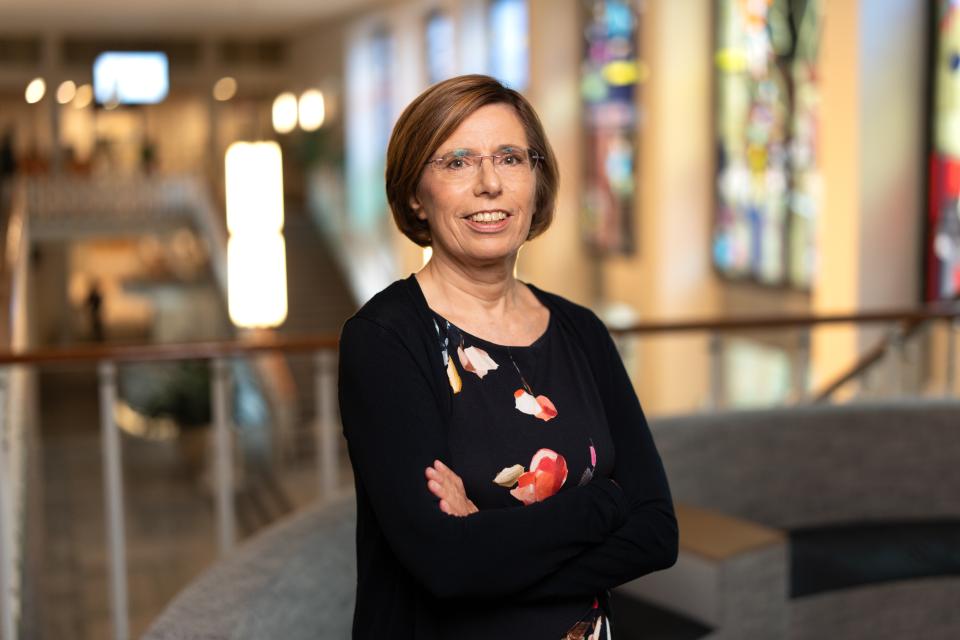 Portret van Jonneke Oosting, zij staat met armen over elkaar in grote ruimte.