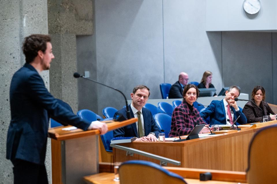 plenaire zaal met Kamerlid achter het spreekgestoelte en vier bewindspersonen in vak K