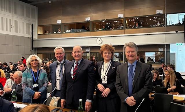 Op de foto staat de Nederlandse delegatie in de vergaderzaal op een rijtje. De delegatie bestond uit Eerste Kamerleden Farah Karimi (delegatieleider, GroenLinks-PvdA), Rian Vogels (VVD), Robert van Gasteren (BBB) en Boris Dittrich (D66) en Tweede Kamerlid Eric van der Burg (VVD).