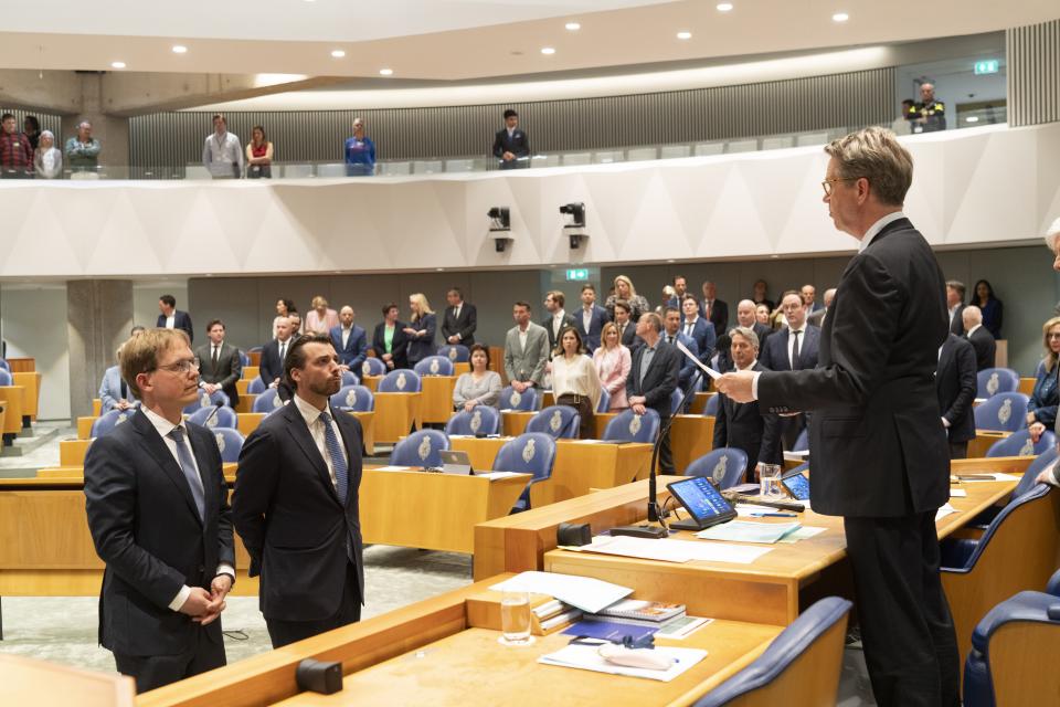 Pepijn van Houwelingen en Thierry Baudet staan in het midden van de plenaire zaal. Kamervoorzitter Martin Bosma spreekt hen toe vanachter het spreekgestoelte.