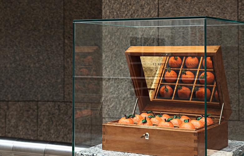 Het kunstwerk 'Appeltjes van Oranje', met 12 oranje appeltjes in een houten kistje