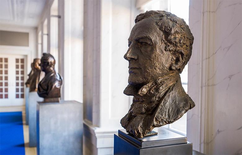 Bronzen borstbeelden, aan de raamkant van de Rooksalon.