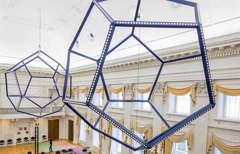 Twee geometrische kroonluchters met blauwe randen.