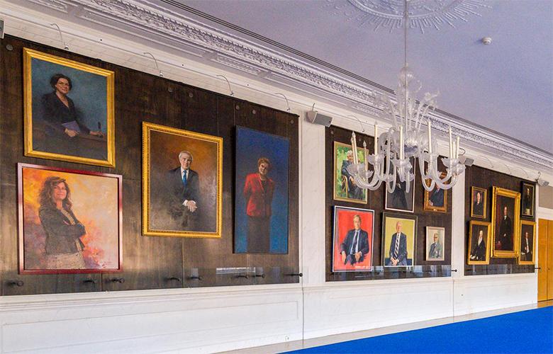 Zicht op de muur in de Rooksalon, met de geschilderde portretten van Kamervoorzitters.
