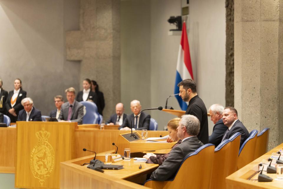 De Oekrainse president Zelensky staat achter het spreekgestoelte in vak K en spreekt de Kamerleden toe.