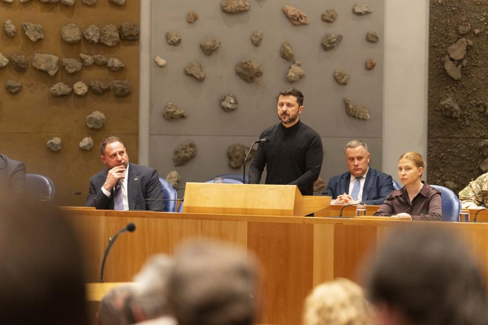 De Oekraïense president Volodymyr Zelensky spreekt in de plenaire zaal van de Tweede Kamer vanuit vak K de zittende Kamerleden toe.