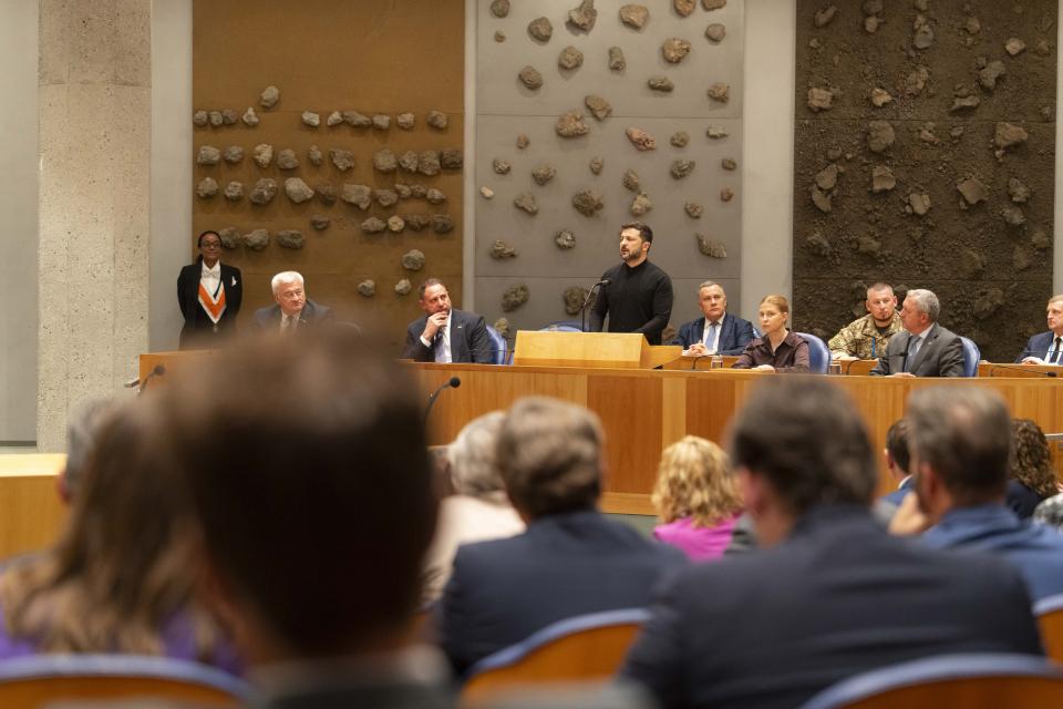 De Oekraïense president Zelensky spreekt vanaf de plek waar normaal gesproken bewindspersonen het woord voeren. Op de voorgrond de Kamerleden in de plenaire zaal.