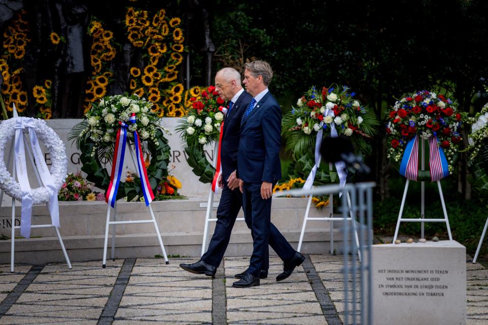 Kamervoorzitter Martin Bosma en naast hem Eerste Kamervoorzitter Jan Anthonie Bruijn lopen tussen de kransen bij het monument terug naar hun stoelen. 