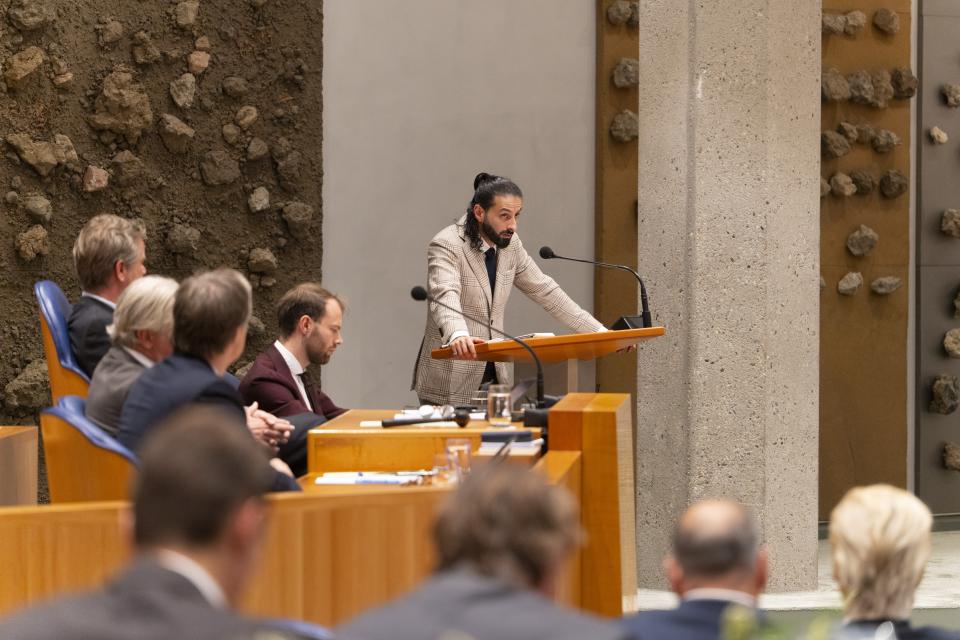 Achter het spreekgestoelte de voorzitter van de commissie voor het Onderzoek van de Geloofsbrieven, die verslag uitbrengt. 