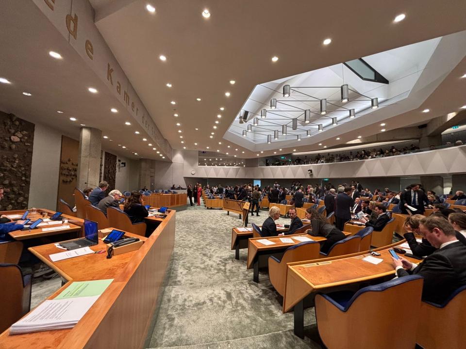 De plenaire zaal gezien vanaf de zijkant, links het voorzittersgestoelte en rechts de Kamerbankjes. 