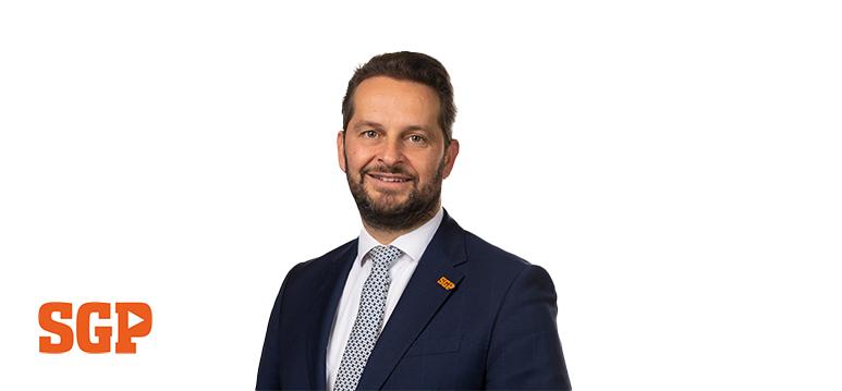 Portretfoto André Flach met partijlogo SGP