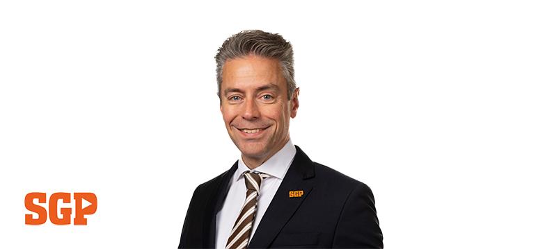 Portretfoto Chris Stoffer met partijlogo SGP