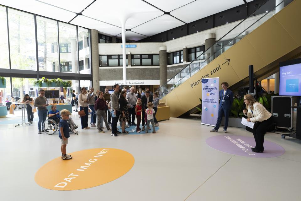 In de Statenpassage liggen twee grote, ronde stickers op de grond. Op één daarvan staan de woorden 'Dat mag wel'. Een jongetje staat op deze sticker. Op de andere sticker staat een grote groep mensen. De tekst op de sticker is daardoor niet leesbaar.