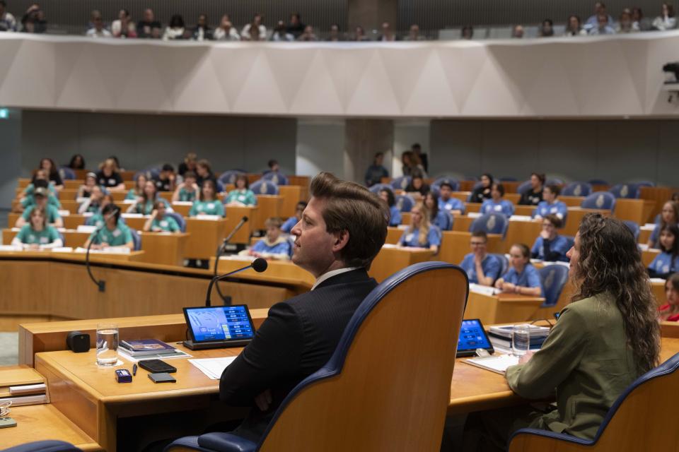 Op de voorgrond zit Kamervoorzitter Thom van Campen en in de bankjes van de plenaire zaal zitten kinderen.