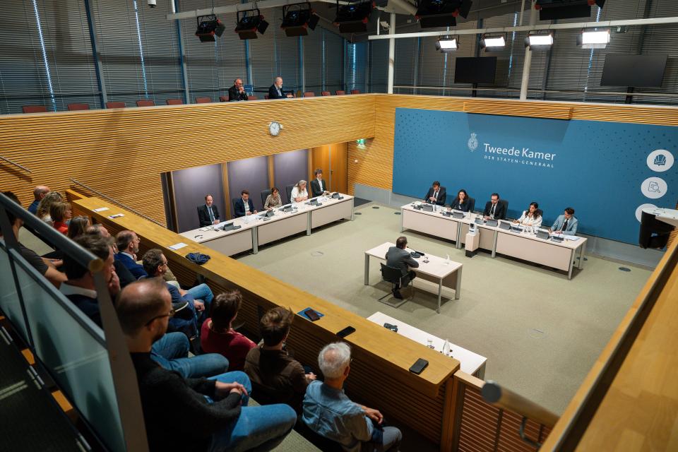 Enquêtezaal van boven gezien. Tegenover de parlementaire enquêtecommissie zit Diederik Gommers.