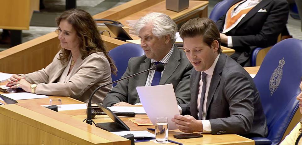 Kamervoorzitter Thom van Campen leest van papier de afsluitende speech voor. Hij is rechts in beeld, naast hem de Griffier. 