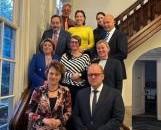 Tien delegatieleden die deelnemen aan de bijeenkomst staan met elkaar op de foto op een trap in het kantoor van het Interprovinciaal Overleg (IPO) in Den Haag.