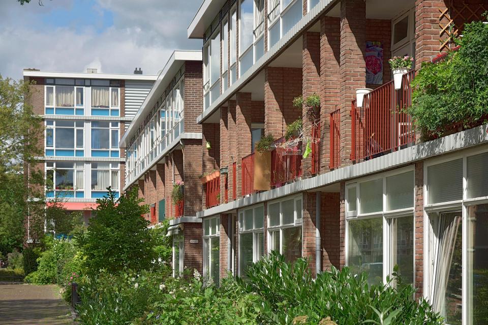 Portiekflat met balkons en struiken op de voorgrond