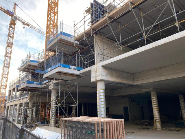 Appartmentencomplex in aanbouw, links enkele grote kranen. 