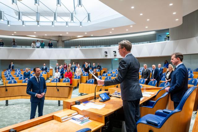 Kamerlid Bart Bikkers staat in het midden van de plenaire zaal. Kamervoorzitter Martin Bosma spreekt hem toe.