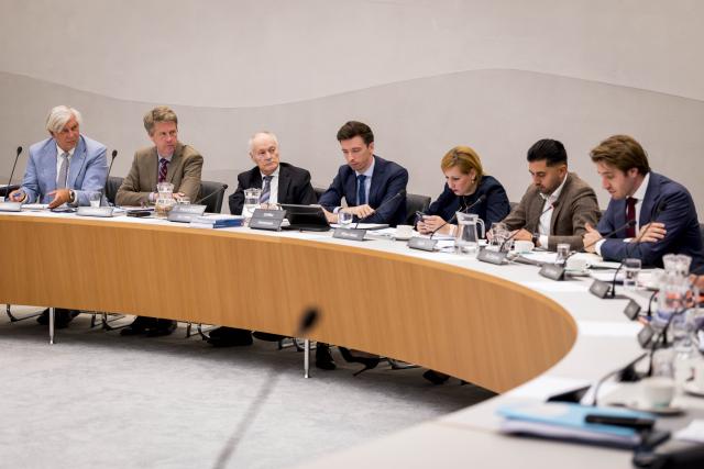 Achter een halfronde tafel een aantal Kamerleden van de commissie Binnenlandse Zaken. Geheel links Griffier Peter Oskam en Kamervoorzitter Martin Bosma. 