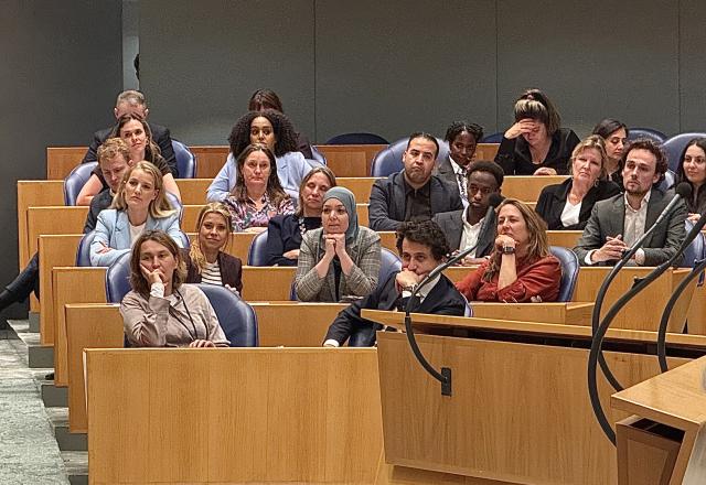 Kamerleden in hun zetels, luisterend naar de afscheidswoorden van Kamervoorzitter Thom van Campen. In het midden Esmah Lahlah. 